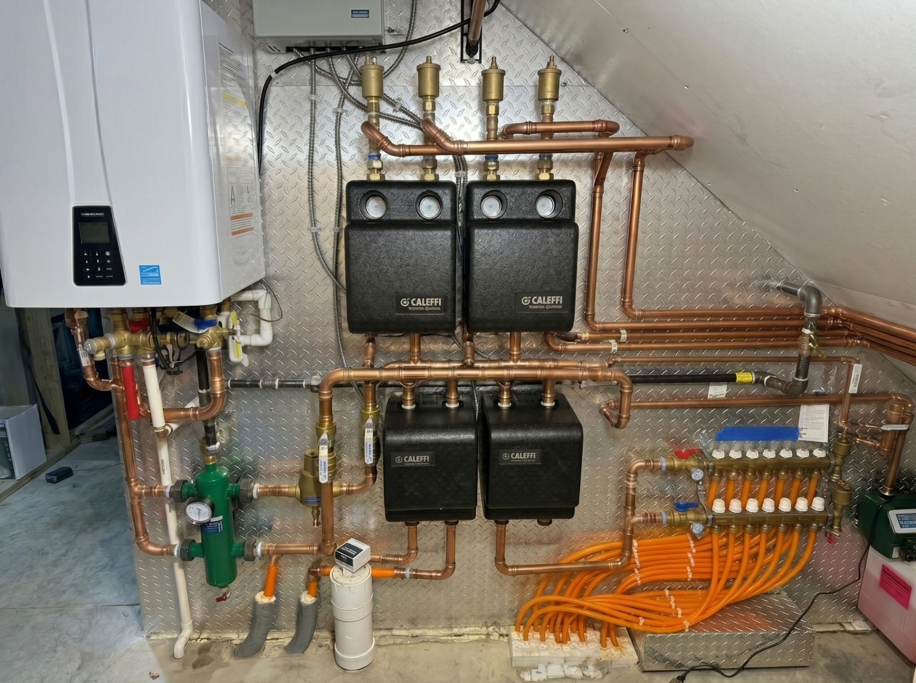High-efficiency wall-mounted boiler with copper manifolds and Caleffi hydronic separators in a custom mechanical room