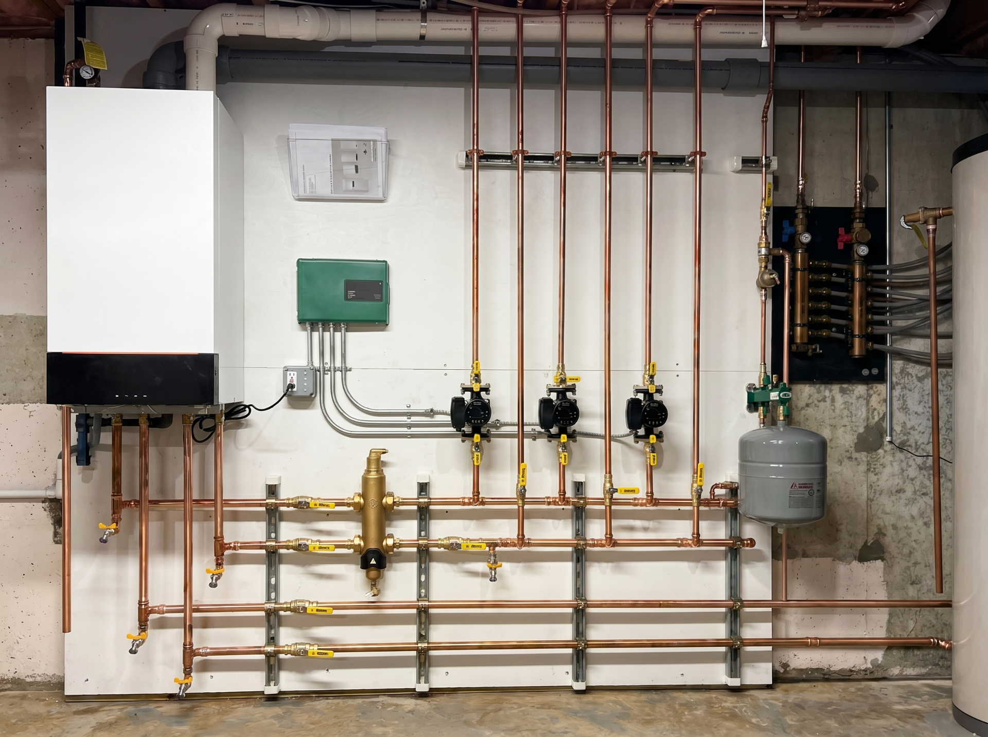 Wall of zone thermostats controlling a multi-zone hydronic system in a custom home